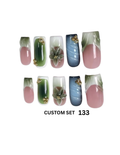 Custom press-on nail set featuring a variety of designs including green and pink gradients, blue and pink gradients, 3D leaves, and gold bead accents