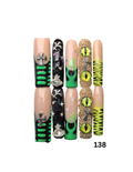 Press-on nails arranged in two columns on a white background, featuring gothic designs including green stripes, black glitter, silver crosses, green alien eyes, and neon yellow zig-zag patterns.