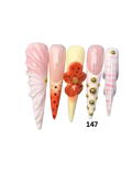 Decorative press-on nails feature pastel pink, cream, orange, and white designs with gold bead accents and a 3D floral detail.