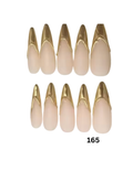 Ten false press-on nails in a pointed almond shape, featuring a sheer nude-pink base with a metallic gold V-shaped accent at the tips