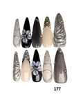 Ten artificial press-on nails. The nails feature various designs including metallic silver, black, glossy nude, and marble patterns, with two decorated with 3D floral nail art.